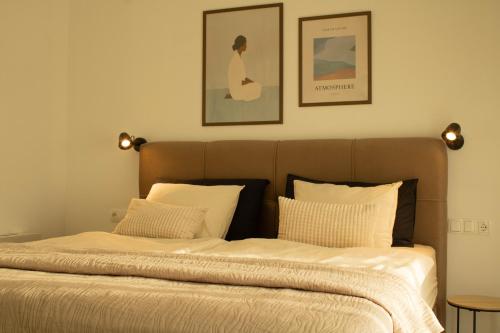 a bed with two white pillows and two pictures on the wall at Casa Kapela in Donji Koncovčak