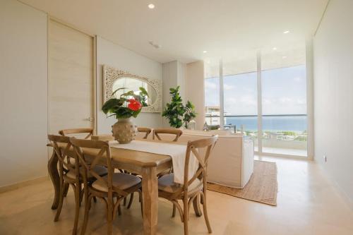 a dining room with a table and chairs and the ocean at Modern apt with 2 BR BBQ and views in Cartagena de Indias