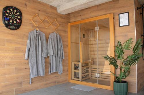 a room with wooden walls with clothes hanging on hooks at Casa Kapela in Donji Koncovčak
