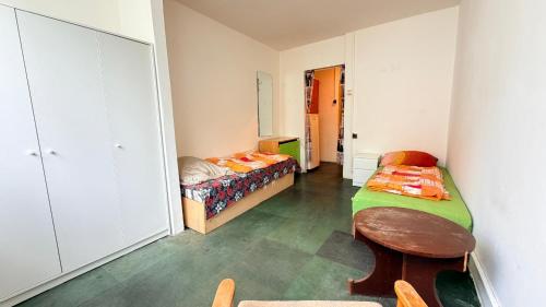 a room with two beds and a table in it at Ubytování U Hráze in Liberec