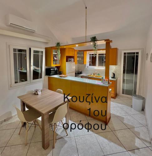 a kitchen with a wooden table and a table and chairs at Aronis Spyros Panoramic Seaview Apartments in Longós
