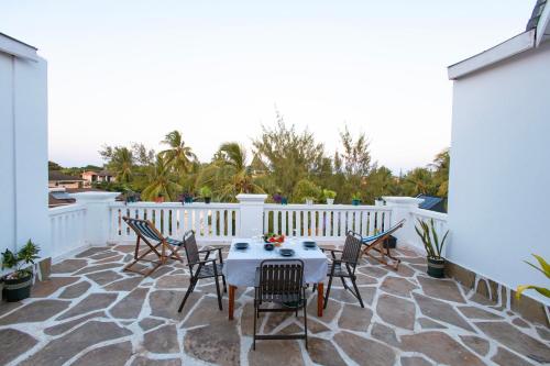 a patio with a table and chairs on a white fence at Diani Luxe Villa in Mombasa