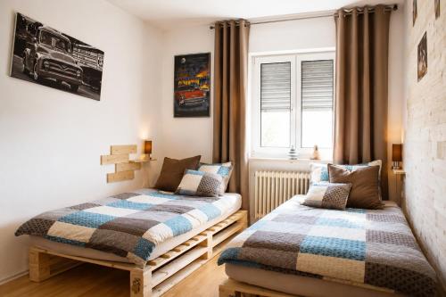a bedroom with two beds and a window at Ferienwohnung Schaftnach Rednitzblick nähe Messe in Schwabach