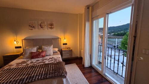 a bedroom with a bed and a large window at Luxury Ría Noia in Noya