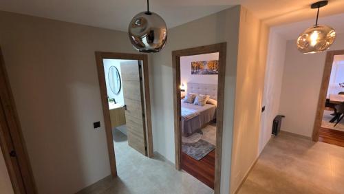 a hallway leading to a bedroom with a bed and a mirror at Luxury Ría Noia in Noya