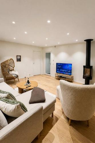 a living room with a couch and a tv at The View - 4BR Central Voss - The Voss Collection in Vossevangen