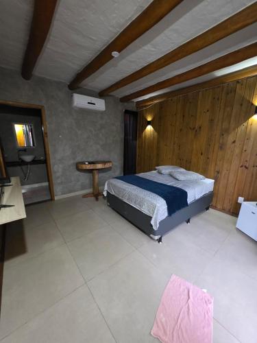 a bedroom with a bed and a table in it at Formosa Suites in Bonito