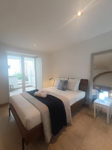 a bedroom with a large bed and a window at Tomarhousing - Style in Tomar
