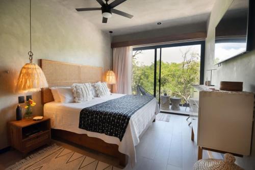 a bedroom with a bed and a large window at Interior designers second home FREE BIKES in Tulum