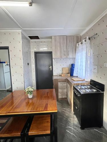 a kitchen with a black stove and a wooden table at The Tiny House - Solwezi in Solwezi