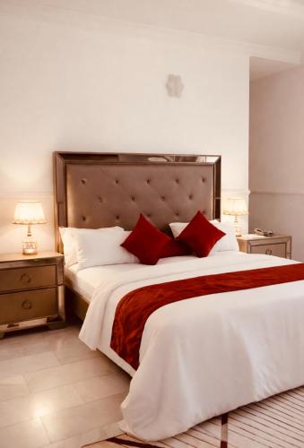a bedroom with a large white bed with red pillows at The Castle Private Villa in Aso