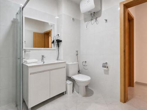 a white bathroom with a toilet and a sink at Portal de Santa Maria in Santa Maria
