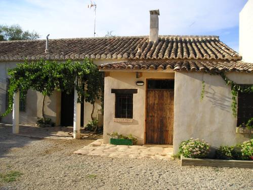 ビリャロブレドにあるCasa Rural La Navarraの庭に木製の扉がある小さな家