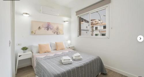 a white bedroom with a bed and a window at Habitaciones IFAE in Alcalá
