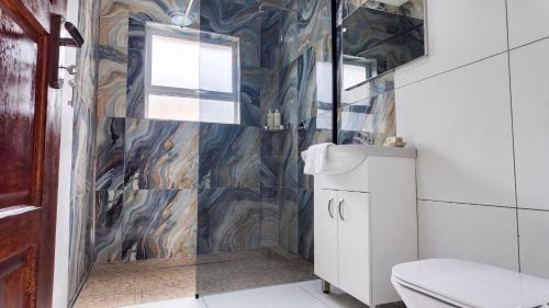 a bathroom with a toilet and a glass shower at SAOB Property- South A in Germiston