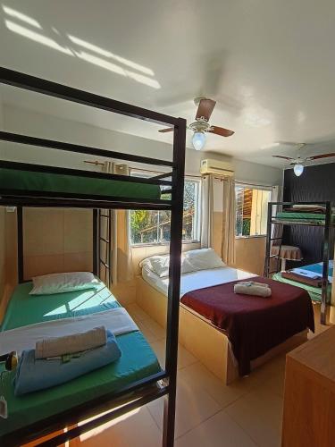 a bedroom with two bunk beds and a room with another bed at Mata Virgem Hostel e Pousada in Abraão