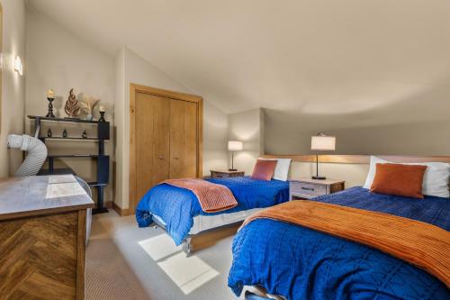 a bedroom with two beds with blue and orange at Ski House 235 - Bend Comfy Condo in Bend