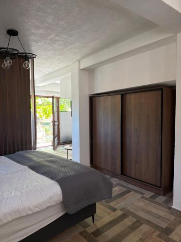 a bedroom with a large bed with a large wooden cabinet at Saymon apartment Trpejca in Ohrid