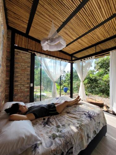 a woman laying on a bed in a bedroom at Cultivarte in Anapoima