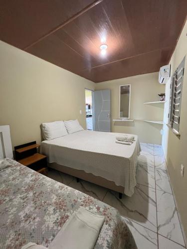 a room with two beds and a couch in it at Chalés Panulirus in Icapuí