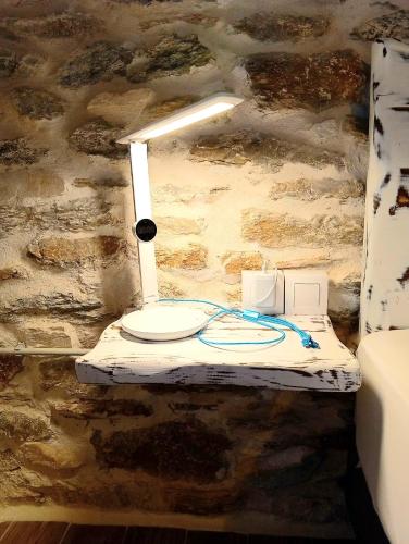 a table with a light on a stone wall at Tsonos Home in Keramídhion