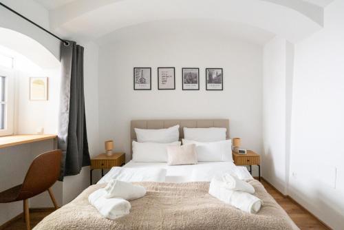 a bedroom with a white bed with white pillows at Coyhomes Steyr Riverside - Serviced Apartments in Steyr