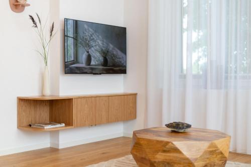 a living room with a tv and a wooden table at Unique apartment with all comforts and sauna in Otepää