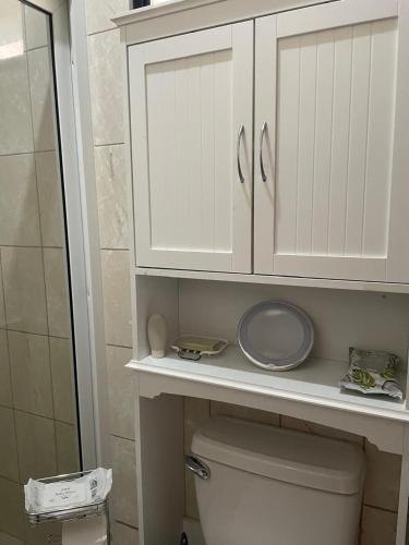 a bathroom with a white cabinet above a toilet at Gasakam in San Pedro Sula