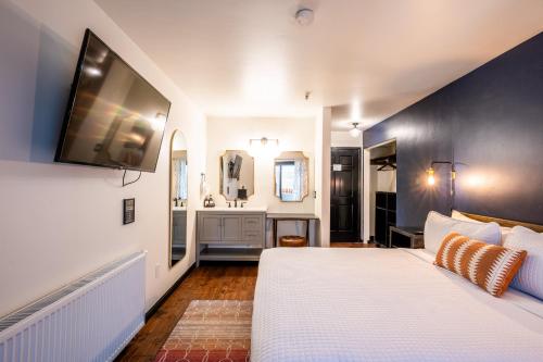 a bedroom with a large white bed and a bathroom at Hotel Frisco in Frisco
