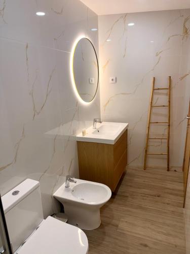 ein Badezimmer mit Toilette, Waschbecken und Spiegel in der Unterkunft Recanto do Cávado in Barcelinhos