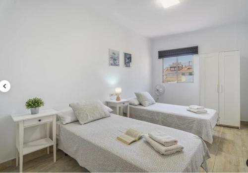 a white room with two beds and a window at Apartamento IFAE 3 in Guía de Isora