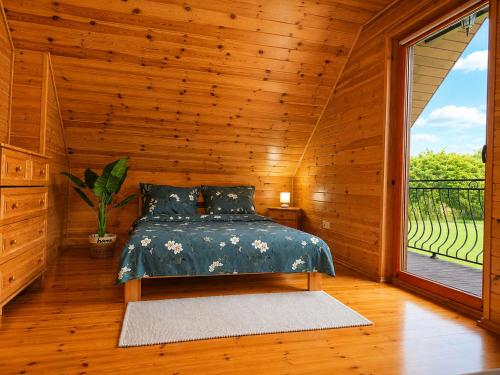 a bedroom with a bed and a large window at Morenowa Dolina Rusinowo in Rusinowo