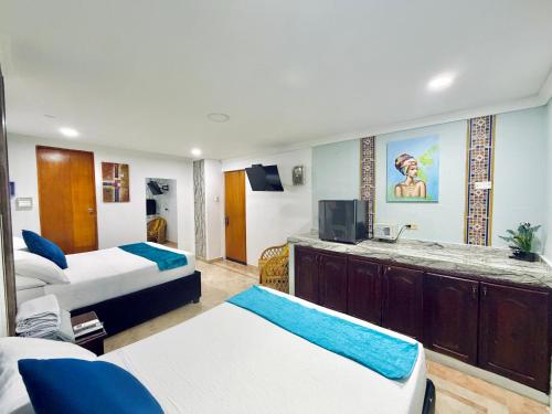 a hotel room with two beds and a tv at Hotel Marie Real Cartagena in Cartagena de Indias