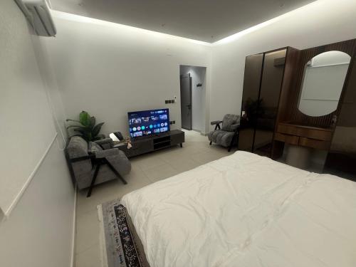 a bedroom with a large bed and a television at Levin in Al Majma'ah
