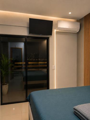 a bedroom with a bed and a tv on the wall at Excelente apartamento aconchegante in Taguatinga