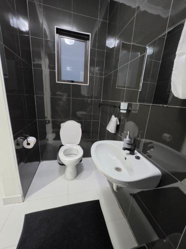a bathroom with a white toilet and a sink at SADO Guesthouse in Katima Mulilo