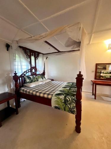 a bedroom with a bed with a canopy at Mepoho Beach Villa Watamu in Watamu