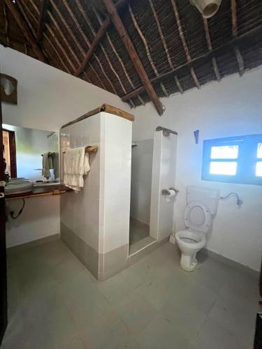 a bathroom with a toilet and a shower at Mepoho Beach Villa Watamu in Watamu