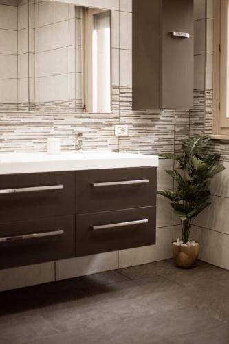 a bathroom with a sink and a potted plant at XIII Tempio in Cisterna di Latina