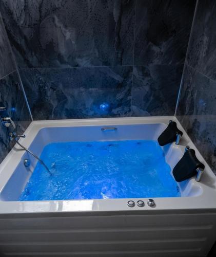 a bath tub filled with blue water in a bathroom at ViLLA ANGEL AHMET HASAN in Belek