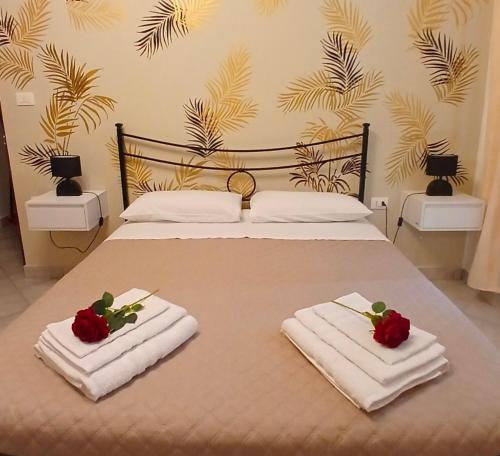 a bed with two towels and two roses on it at Marruvium 1937's in Avezzano