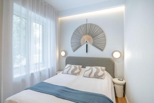 a bedroom with a bed and a fan on the wall at Luxorious Japandi design apartment in Otepää