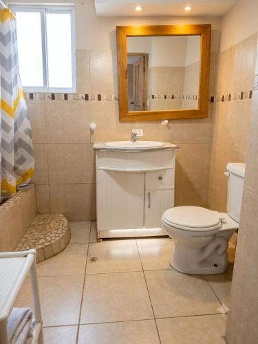 a bathroom with a toilet and a sink and a mirror at Casa Refugio del Amanecer en Baños de Agua Santa in Lligua