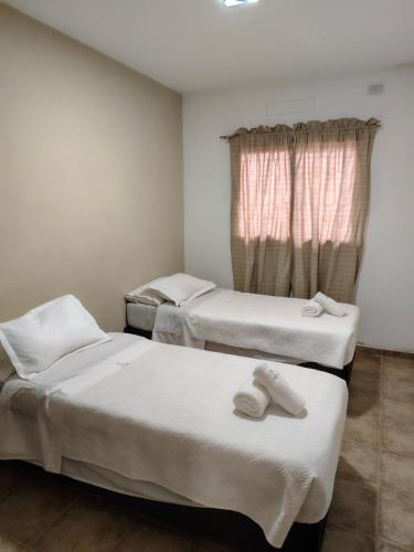 two beds in a room with towels on them at Lihuel 1 AG in Alta Gracia