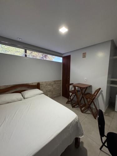 a bedroom with a bed and a table and a window at Hotel Cabana in Parauapebas