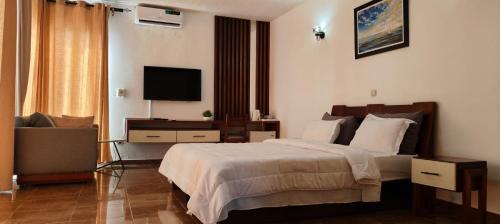 ein Hotelzimmer mit Bett und Fernseher in der Unterkunft Hotel Atlantic View in Muanda