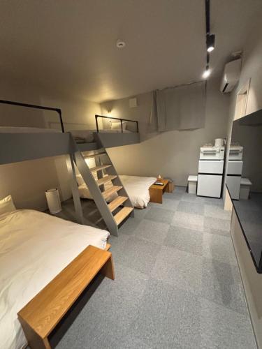 a room with two bunk beds and a kitchen at HOTELanoh in Saga