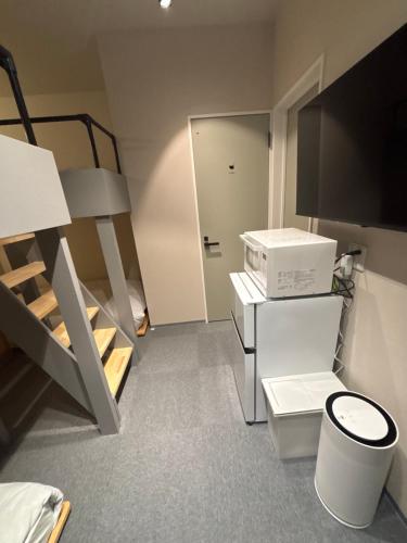 a small room with a bunk bed and a toilet at HOTELanoh in Saga