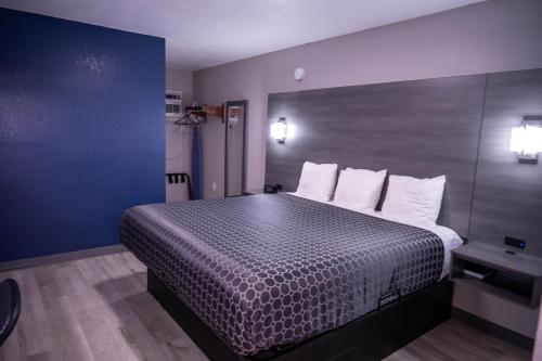 a hotel room with a large bed with white pillows at Budget Inn in Alamogordo