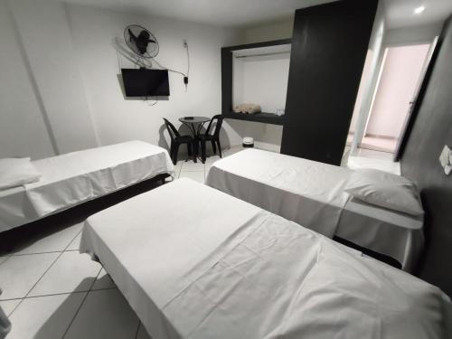 a hospital room with two beds and a table at Stratus Vila Hotel in Volta Redonda